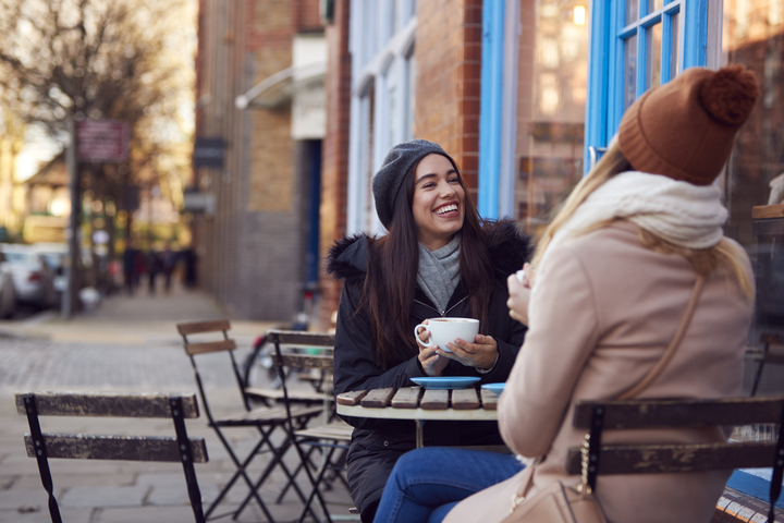 Two friends enjoying a coffee on a break playing Treasure Hunt Brighton